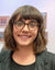 Aimee Buyea in front of artworks hanging on a gallery wall